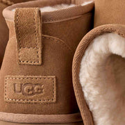 Close-up of the UGG Classic Ultra Mini Platform heel pull tab, UGG logo patch and cream sheepskin lining
