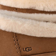 Close-up of the UGG Zora Ballet Flat showing the cream sheepskin collar, chestnut suede and embossed UGG logo