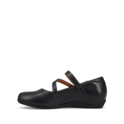 Taos Women's Banter flat in black leather, medial inside profile showing the strap anchor and low wedge