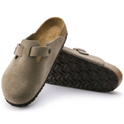 Birkenstock Boston clog in Taupe suede, one shoe upright beside one tilted to show the EVA outsole tread